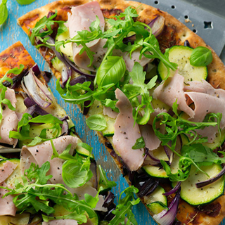 2 pizza halves, topped with wafer ham, sliced courgettes and rocket.